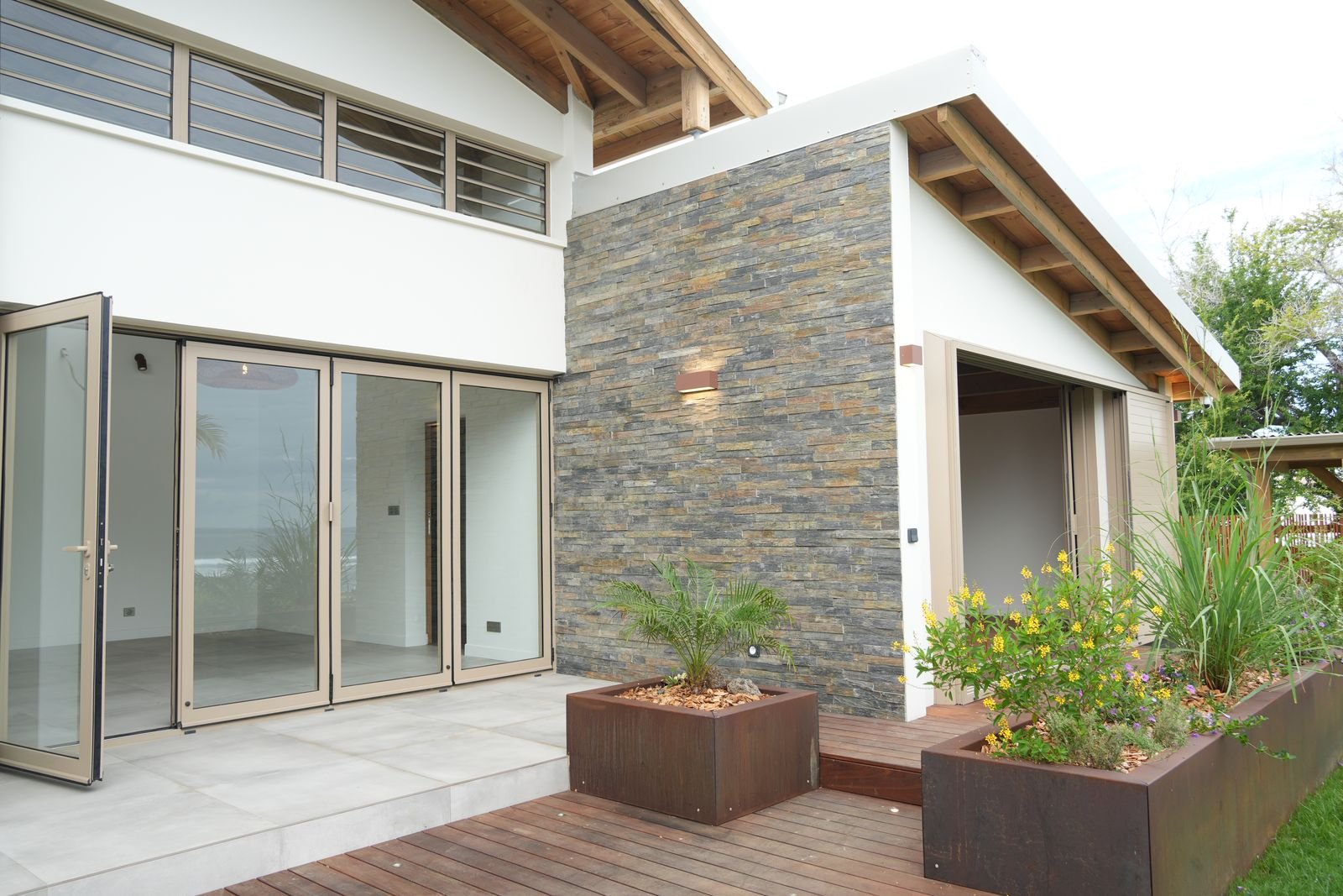 Détail de terrasse en bois et mur en pierre